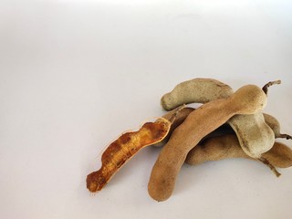 Tamarind with brown pods on a white background