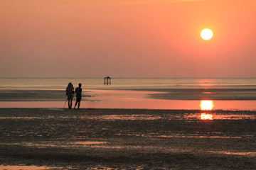 The silhouette of lovers on the evening beach.