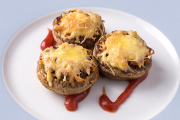 baked mushrooms with cheese serving on a plate.