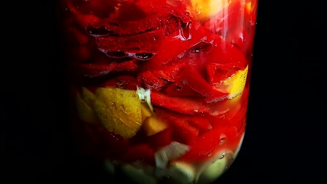 Chiles picantes y frutas fermentando en botella vidrio