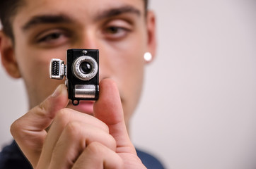 Young man with a miniature camera