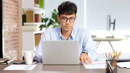 Young asian businessman concentrate on working with laptop computer at office, Asian office man comtemplate on laptop, Asia male business people and office lifestyle concept