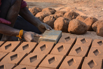 Hands of worker making bricks with clay and mud