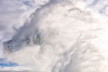 Obraz premium a Pro snowmobiler makes a jump with a big blast of snow and epic falls. bright snowmobile and suit. snowmobilers sports riding.