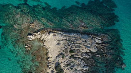 Fototapeta na wymiar Aerial view of Vourvourou beach, small peninsula in turquoise water of Aegean sea. Waves beating cliff rocky coastline. Halkidiki, Greece.