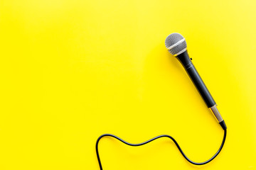 TV news concept. Microphone on yellow background top-down copy space