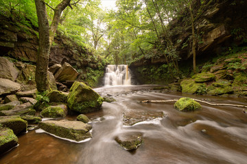 Obraz premium Colourful waterfall scene, and the surrounding woodland. Taken with a slow shutter to blue the water.