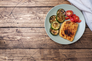 Schnitzel of chicken and zucchini cooked on the grill. Fresh tomatoes on a plate. Ready delicious...