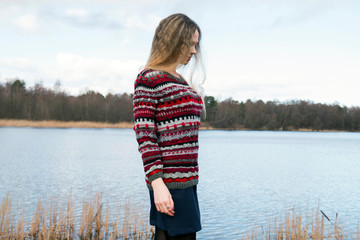 A woman walks alone along the lake, morning meditation in nature