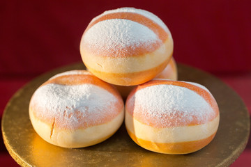 Vienna, Austria - Jan 30, 2020: View on three a pile of Krapfen (austrian doughnuts). Illuminated by sunlight. With powdered sugar on top. Austrian speciality.