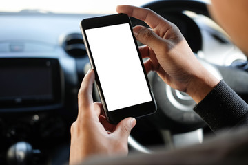 Cropped shot view The driver uses the phone while driving. Modern smart phone with round edges. Isolated screen for mockup. Car navigation display in background. 