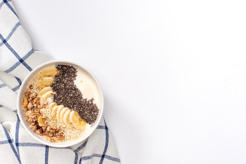 Healthy pineapple, mango smoothie bowl with coconut, bananas, blueberries and granola. Top view scene on a bright background.