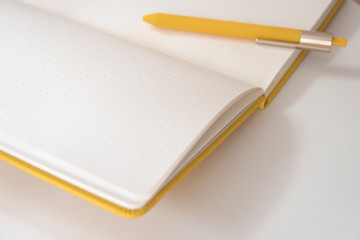 黄色のノートとペン　白紙　ノート　ペン　背景素材　グラフィック背景　ホワイトスペース　コピースペース　余白　黄色　シンプル　スタイリッシュ　背景