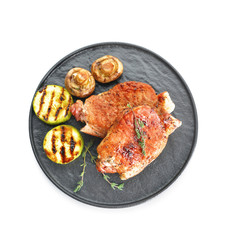 Plate with cooked pork steaks on white background