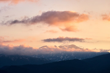 Fototapeta premium mountain peaks at sunset in the clouds