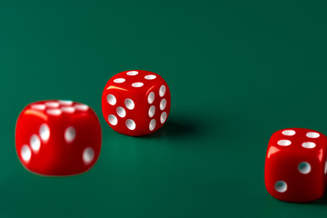 Red dice on green background close up