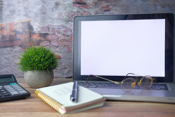 laptop, notepad and calculator on office desk 