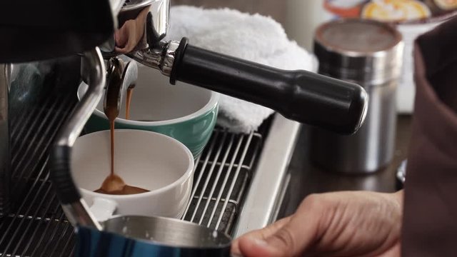 Double shot Espresso coffee being brewed by the machine flowing into the cups 