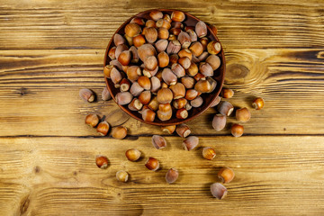 Hazelnuts in ceramic plate on a wooden table. Top view