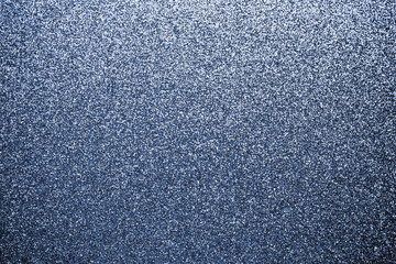 Glitter fabric with sparkles. Blue tinsel background, shiny texture of textile. Luxury fashion. Glossy cloth, material wallpaper.