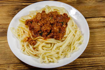 Pasta with bolognese sauce on wooden table