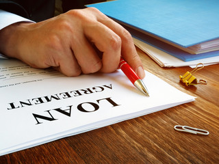 Man reads loan agreement for signing.