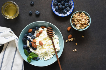Beautiful breakfast - cottage cheese, berries and honey on the kitchen table. Good morning.