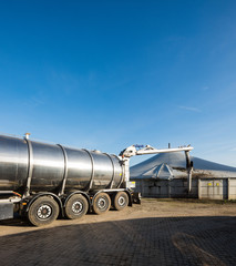 LKW mit Silo Auflieger pumpt Gülle an einer Biogasanlage ab