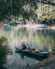 Small Vietnamese boat on a like with beautiful nature.