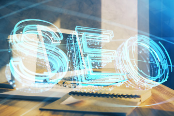 Multi exposure of table with computer and seo drawing hologram. Search optimization concept.