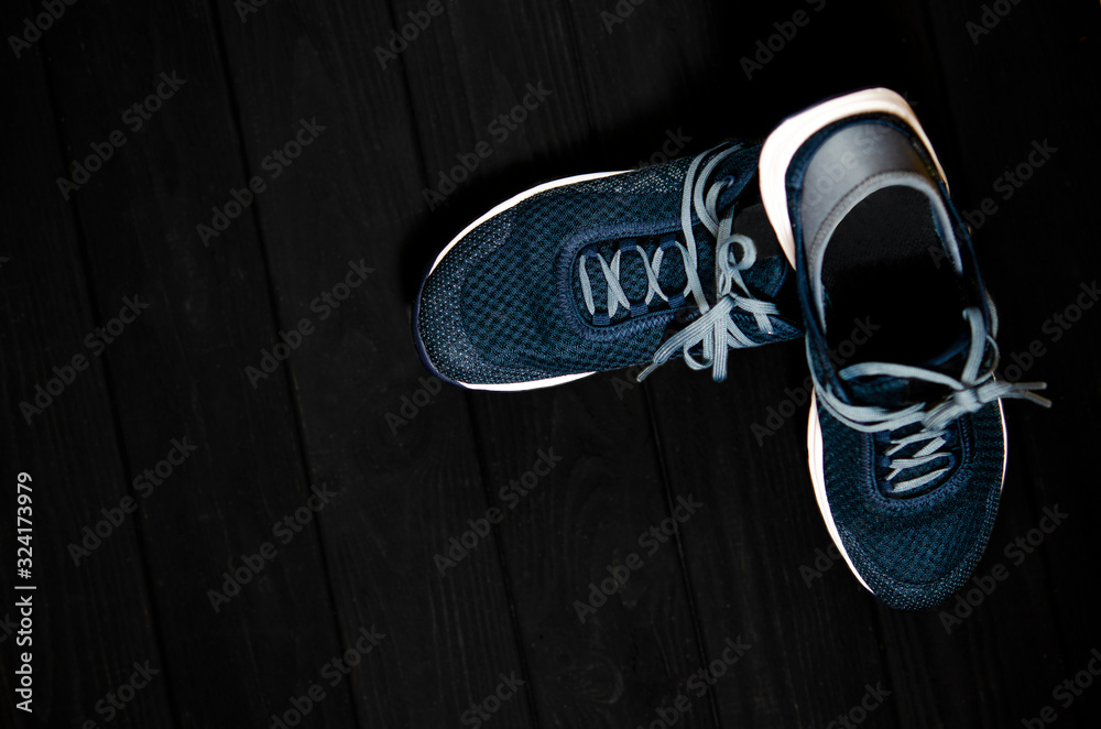 Wall mural Sports shoes for sports and tourism stands on a dark background.