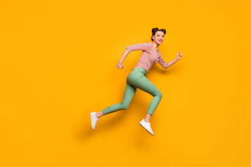 Fototapeta na wymiar Full length photo of pretty lady jumping high rushing low prices sales shopping center wear red white pullover shirt green pants footwear isolated bright yellow background