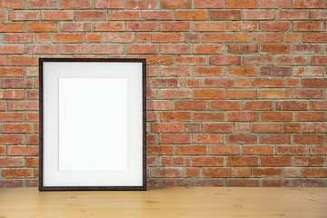 blank black picture frame on the red brick wall and the wooden floor, template poster interior photo 3d background