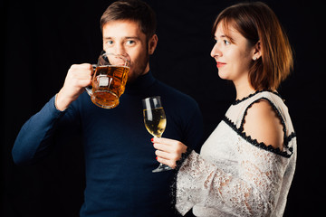 A man and a woman on a black background, a man drinking beer and a woman drinking champagne