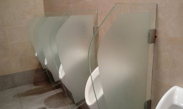 Urinals and glass partition with frosted film for privacy purpose in Men toilet or lavatory and partitions fixed with wall by using stainless steel clip screwed