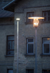 Fototapeta na wymiar A modern metal lantern illuminates the city in the evening. Close-up.
