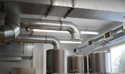 Stainless steel pans. Piping ventilation system. Professional restaurant kitchen.
