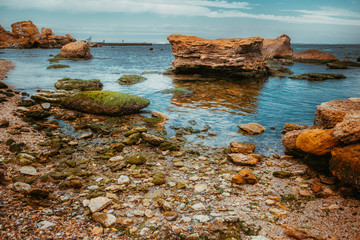 Rocks on the sea beach with beautiful sky