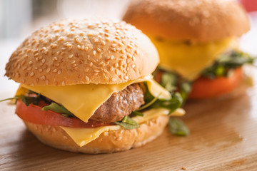 Tasty grilled home made burger cooking with beef, tomato, cheese, cucumber and lettuce. 