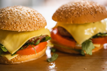 Tasty grilled home made burger cooking with beef, tomato, cheese, cucumber and lettuce. 