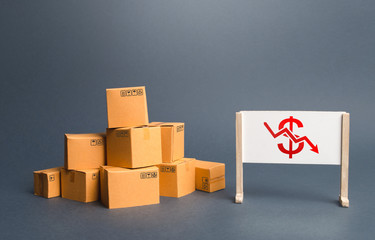 Pile of boxes and easel with red dollar arrow down chart. Drop profits, sales slowdown. Decrease in...