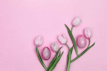 Stone Easter eggs and beautiful pink tulips. Minimal style composition with Easter concept. Spring blossom tree. Top view and copy space.