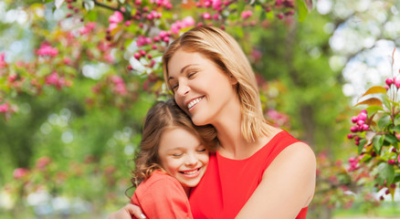 family, motherhood and people concept - happy smiling mother and daughter hugging over cherry...