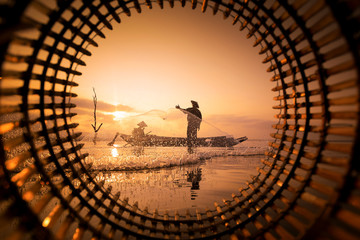 Two fishermen are fishing at the lake during sunset in Chonburi, Thailand. - obrazy, fototapety, plakaty