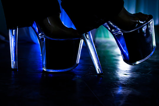 Sexy female legs in shoes and stockings on a dark background.