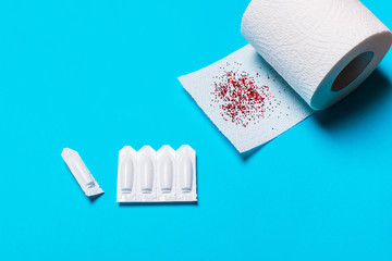 uppository and toilet paper on a blue background