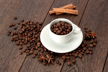 Cup of coffee and coffee beans on wooden table.