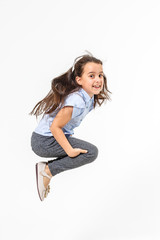 Happy schoolgirl jumping high on white background