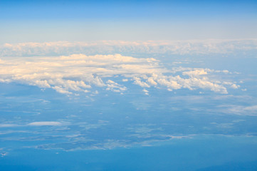 Clouds with ground and sea in the background