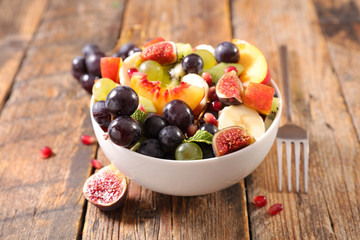 bowl of fruit salad- mixed fruit salad with grape, banana, peach, and fig